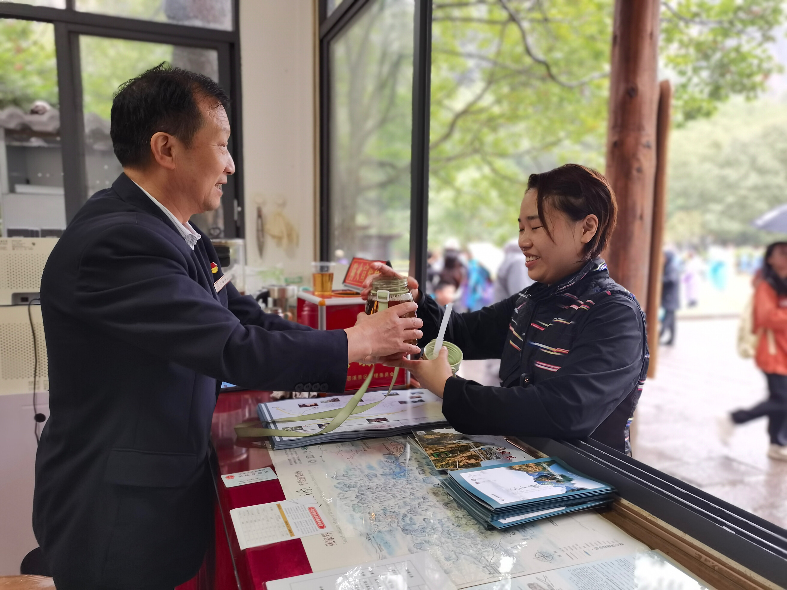 老磨灣大氧吧咨詢臺金鞭溪景區(qū)管委會工作人員為游客免費提供開水。歐華 攝